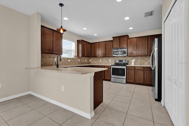 kitchen with sink, hanging light fixtures, stainless steel appliances, tasteful backsplash, and kitchen peninsula