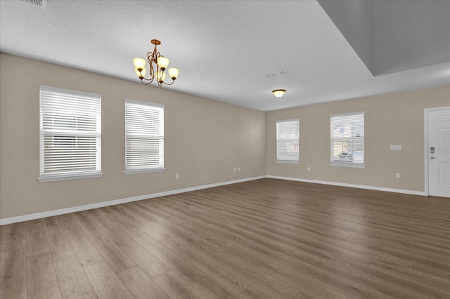 interior space featuring a notable chandelier, dark hardwood / wood-style floors, and a textured ceiling