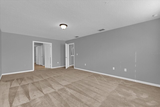 carpeted spare room with a textured ceiling