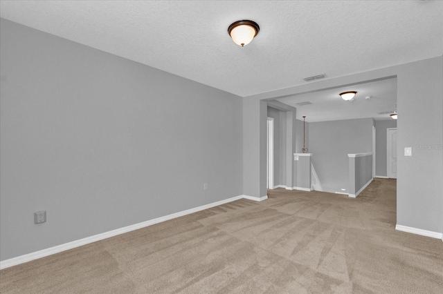 carpeted empty room with a textured ceiling