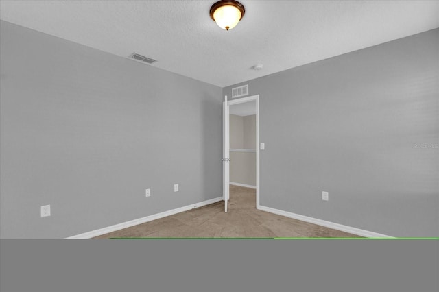 unfurnished bedroom featuring light carpet and a textured ceiling