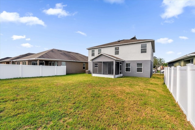 back of property with a sunroom, a fenced backyard, a lawn, and stucco siding