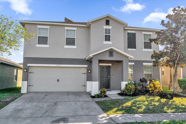 view of front of house with a garage, concrete driveway, and stucco siding