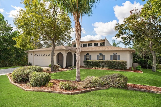 mediterranean / spanish house featuring a front lawn and a garage