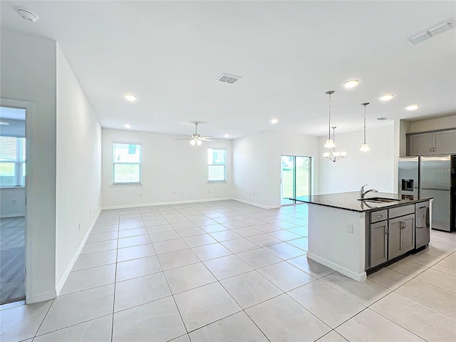 kitchen featuring gray cabinetry, sink, stainless steel fridge with ice dispenser, a kitchen island with sink, and light tile patterned floors