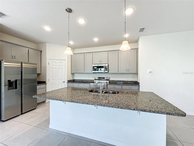 kitchen with a breakfast bar area, a center island with sink, stainless steel appliances, and sink