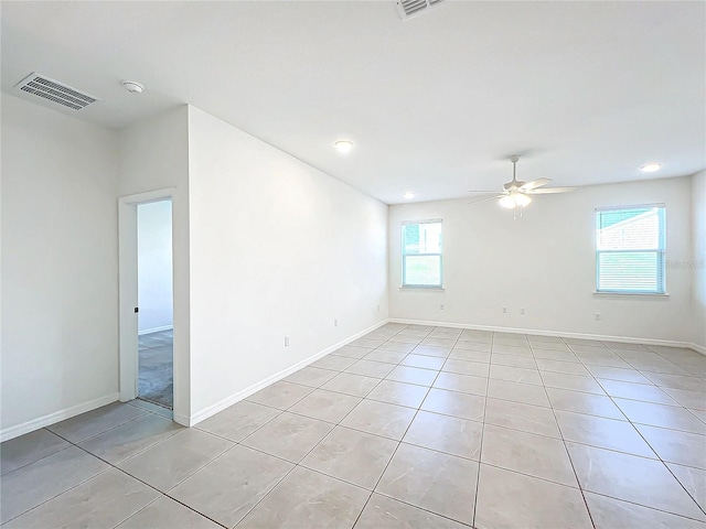 tiled empty room featuring ceiling fan