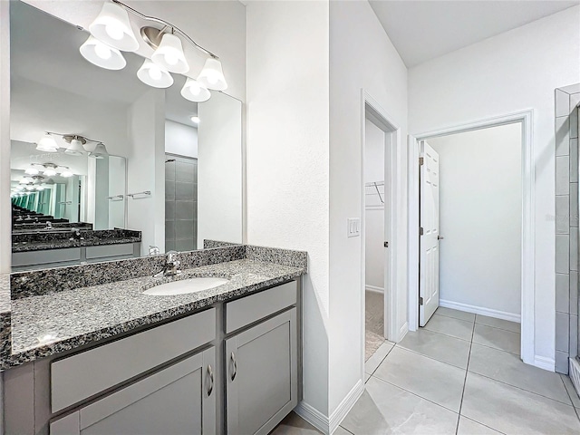 bathroom featuring tile patterned floors, a shower with door, and vanity