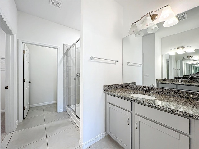 bathroom featuring tile patterned flooring, vanity, and a shower with shower door