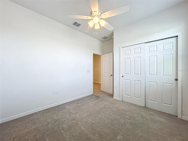 unfurnished bedroom with ceiling fan, light colored carpet, and a closet