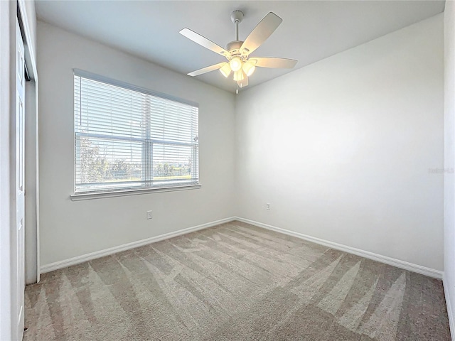 carpeted empty room featuring ceiling fan