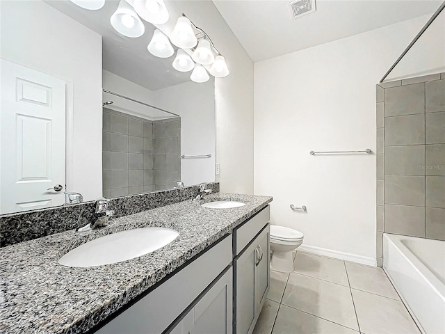 full bathroom with tiled shower / bath, tile patterned flooring, vanity, and toilet