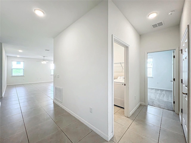 hall featuring washer / clothes dryer and light tile patterned flooring