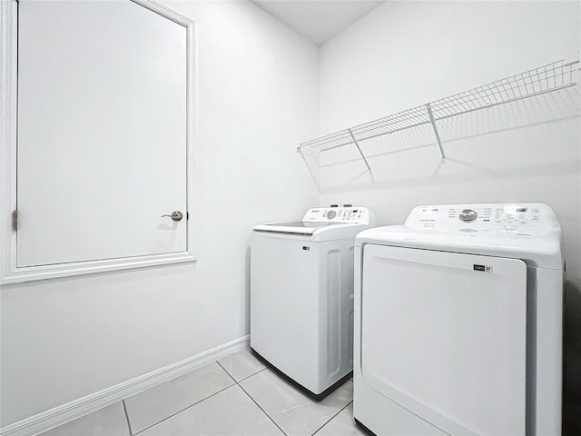 laundry area featuring washing machine and dryer and light tile patterned floors