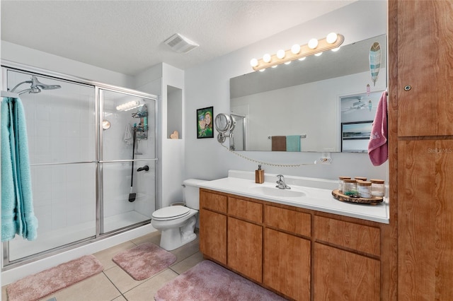 bathroom with vanity, tile patterned flooring, toilet, a textured ceiling, and an enclosed shower