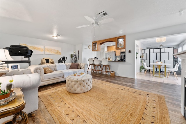 living room with light hardwood / wood-style flooring and ceiling fan