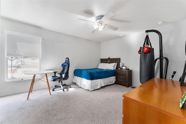 carpeted bedroom featuring ceiling fan and a textured ceiling