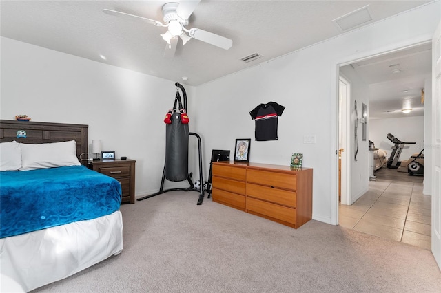 carpeted bedroom featuring ceiling fan and a textured ceiling