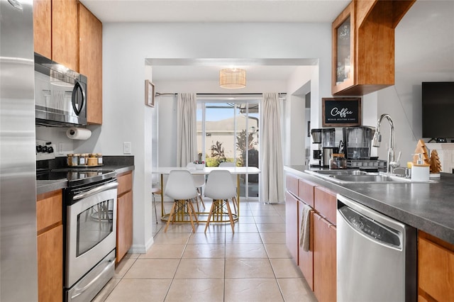 kitchen with sink, light tile patterned floors, and appliances with stainless steel finishes