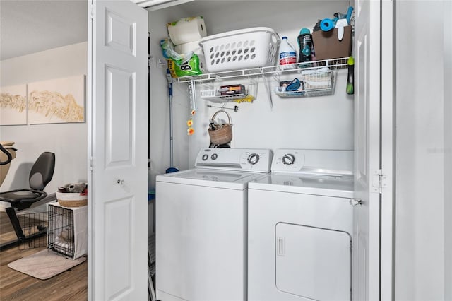 clothes washing area with washer and clothes dryer and dark wood-type flooring