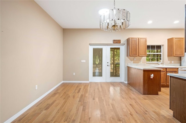 kitchen with french doors, light hardwood / wood-style flooring, decorative light fixtures, and a notable chandelier