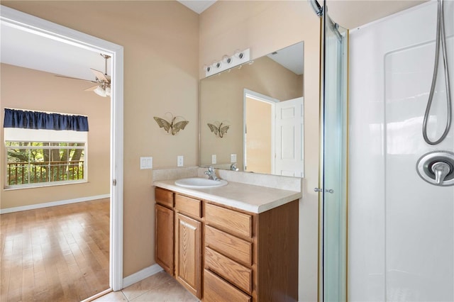 bathroom with ceiling fan, vanity, wood-type flooring, and walk in shower