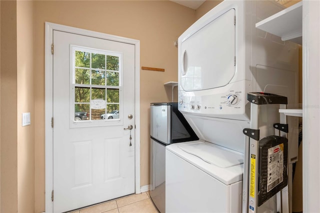 washroom with light tile patterned floors and stacked washer / drying machine