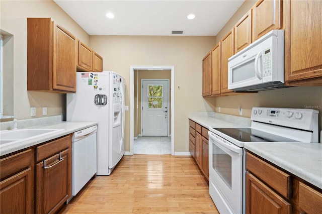 kitchen featuring light hardwood / wood-style floors, white appliances, and sink