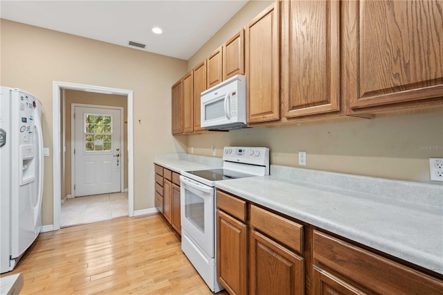 kitchen featuring light wood-type flooring and white appliances