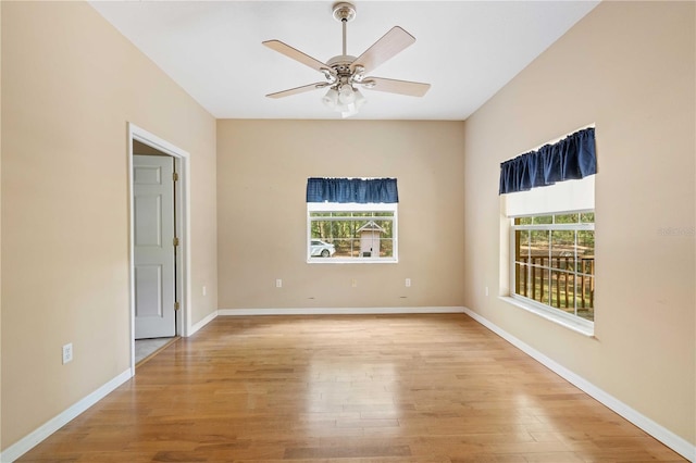 spare room with light hardwood / wood-style floors, a wealth of natural light, and ceiling fan