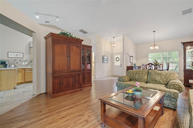 living room with light hardwood / wood-style floors and a notable chandelier