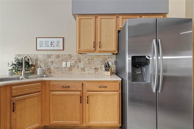 kitchen featuring stainless steel fridge, sink, light brown cabinets, and tasteful backsplash