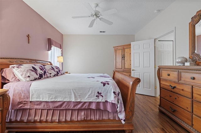 bedroom with a textured ceiling, ceiling fan, dark wood-type flooring, and a closet