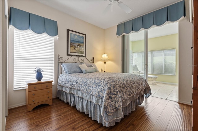 bedroom featuring hardwood / wood-style floors, ceiling fan, and multiple windows