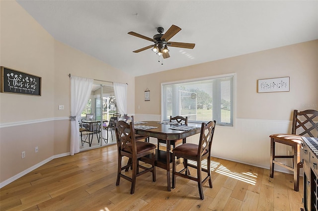 dining room with ceiling fan, light hardwood / wood-style flooring, and vaulted ceiling