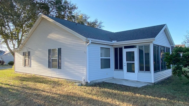 view of home's exterior featuring a sunroom and a yard