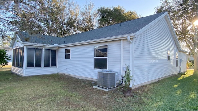 back of property featuring a sunroom, a yard, and cooling unit