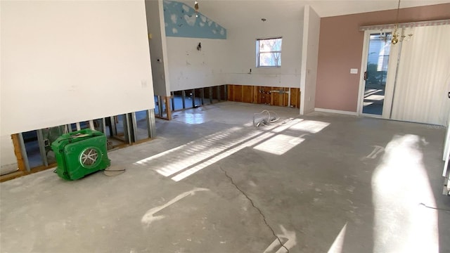 unfurnished room featuring concrete floors and an inviting chandelier