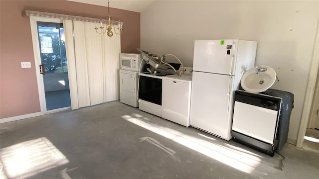 kitchen featuring pendant lighting, white appliances, separate washer and dryer, a notable chandelier, and concrete flooring