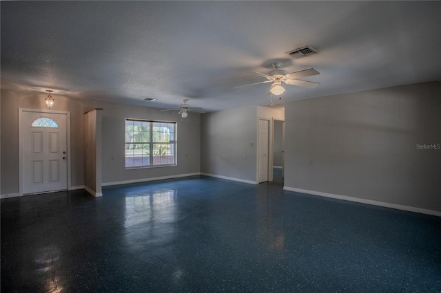 unfurnished living room featuring ceiling fan and a textured ceiling