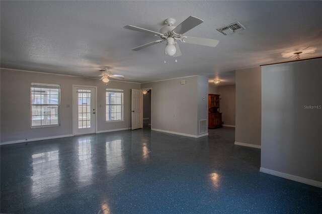 empty room with ceiling fan and a textured ceiling