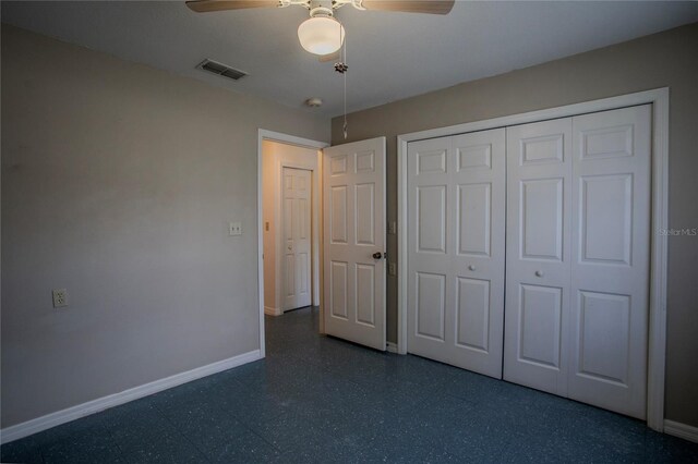 unfurnished bedroom with ceiling fan and a closet