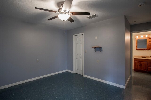 empty room featuring a textured ceiling, ceiling fan, and sink