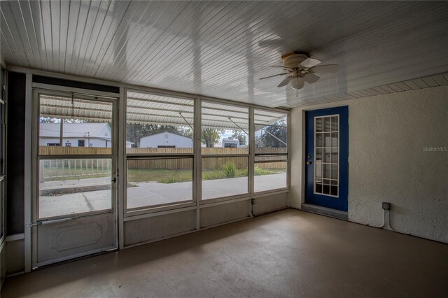 unfurnished sunroom featuring ceiling fan and a wealth of natural light