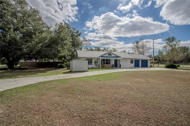 ranch-style home featuring a garage and a front lawn