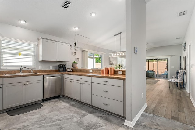 kitchen with vaulted ceiling, sink, decorative light fixtures, dishwasher, and gray cabinets