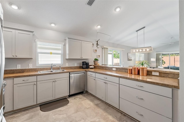 kitchen featuring dishwasher, lofted ceiling, sink, ceiling fan, and decorative light fixtures