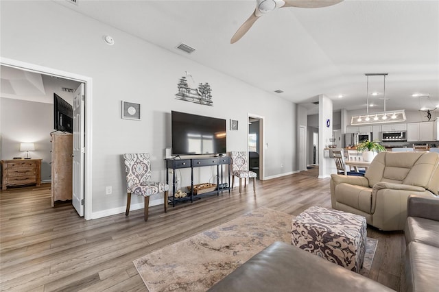 living room featuring hardwood / wood-style floors, ceiling fan, and lofted ceiling