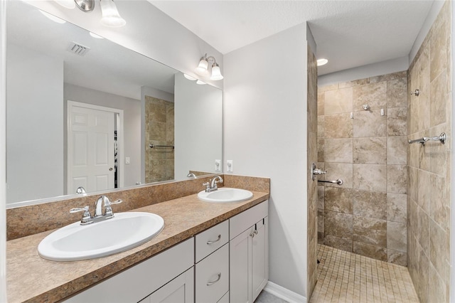 bathroom with vanity and a tile shower