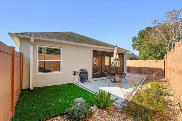 rear view of house featuring a yard and a patio